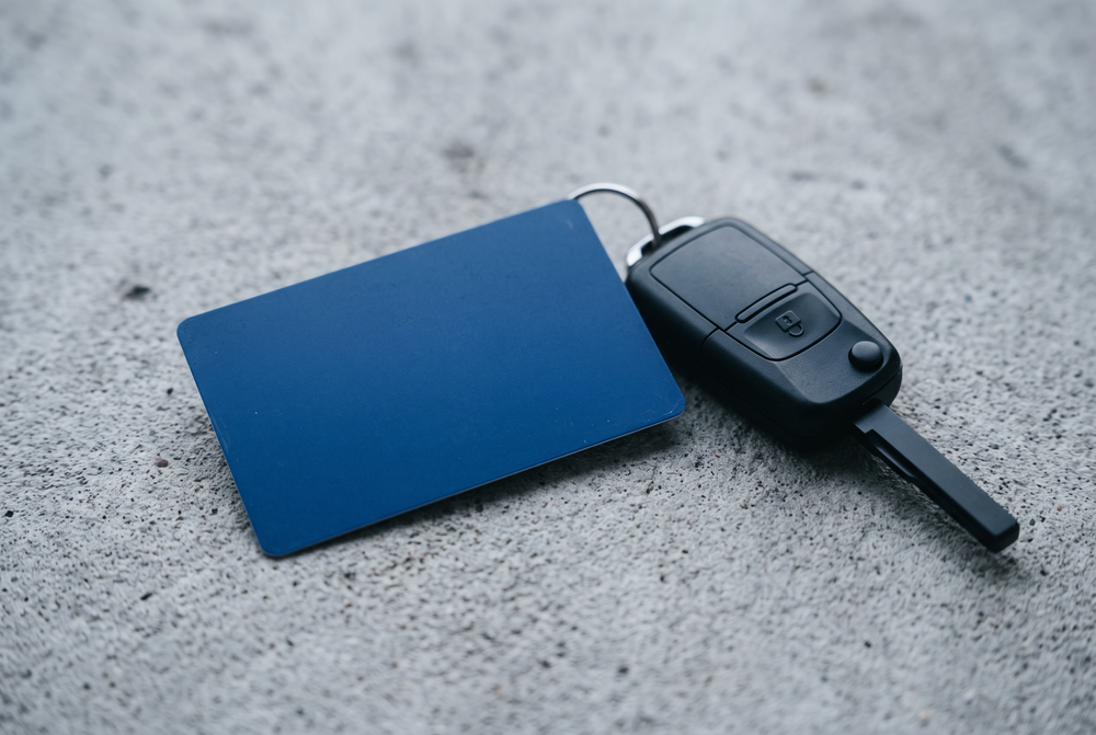 Blaue Karte ohne Aufdruck neben einem Autoschlüssel
